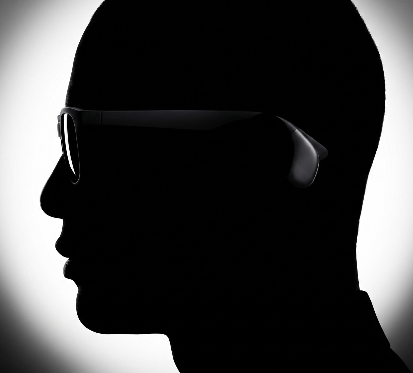 A head in profile wearing the frames, with the node sitting behind the ear